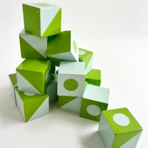 3D-jigsaw-puzzle-blocks A stack of green and white patterned wooden cubes from the 3D Wooden Visual Perception Puzzle, arranged in a playful pile on a white background, with a few cubes scattered at the base.