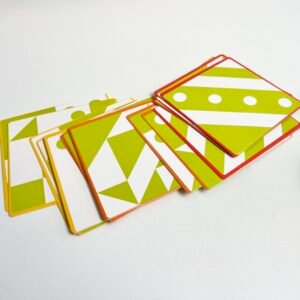 3D-jigsaw-puzzle-cards A fanned arrangement of the colourful challenge cards for the 3D Wooden Visual Perception Puzzle, showcasing various green, white, and yellow patterns with orange and red borders, on a white surface.