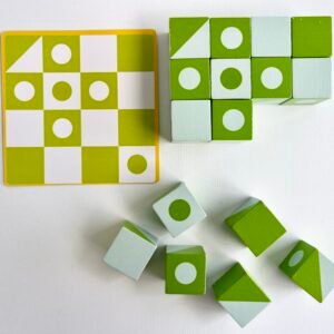 3D-jigsaw-puzzle-copying A top-down view of a green and white 3D Wooden Visual Perception Puzzle card next to a partially completed puzzle using the green and white patterned cubes, with several loose cubes nearby on a white background.