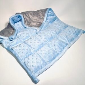 Soft blue and grey two-tone weighted lap pad with minky dimpled texture, folded on a white background, offering sensory comfort.