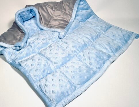 Soft blue and grey two-tone weighted lap pad with minky dimpled texture, folded on a white background, offering sensory comfort.