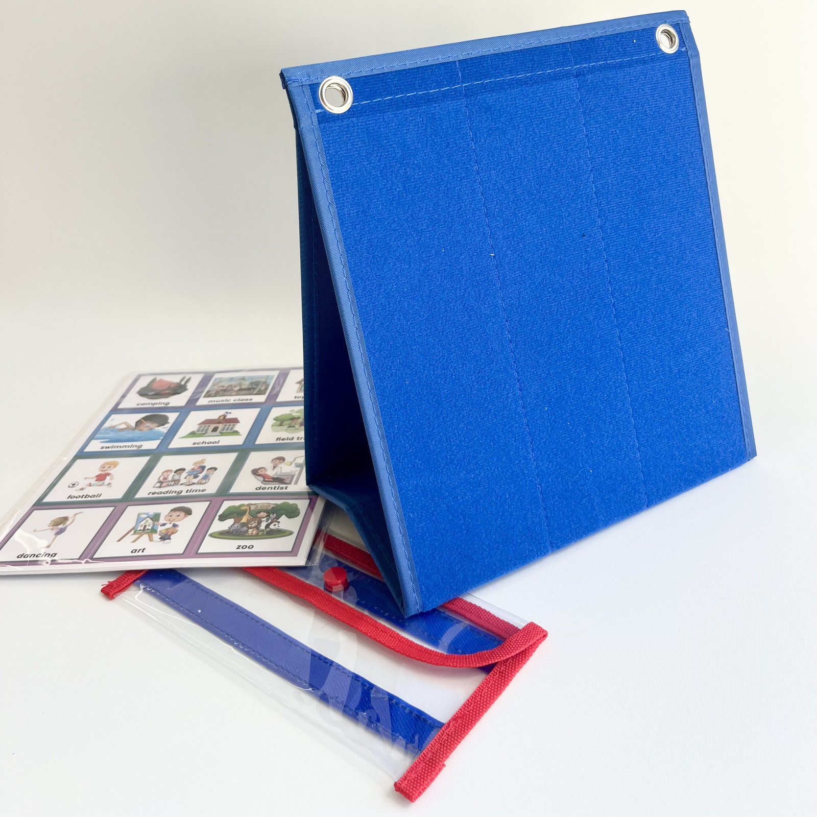 visual-schedule-felt-board-standing Side view of the blue felt tabletop visual schedule board folded, with a clear plastic pouch holding various routine cards and images.