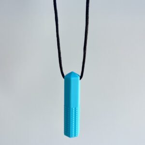 A single blue chewable necklace shaped like a textured stick, hanging on a black cord against a light grey background.