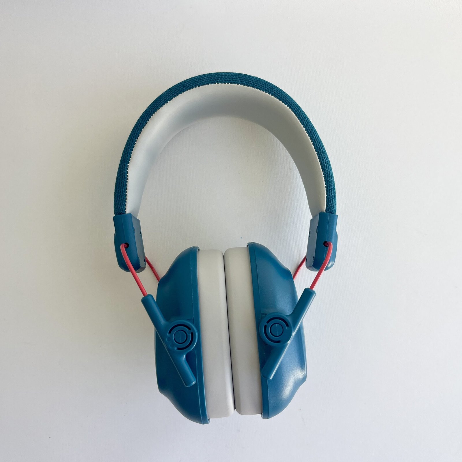 An unfolded blue pair of noise cancelling headphones for children, viewed from the front, highlighting the adjustable headband and ear cups on a white background.