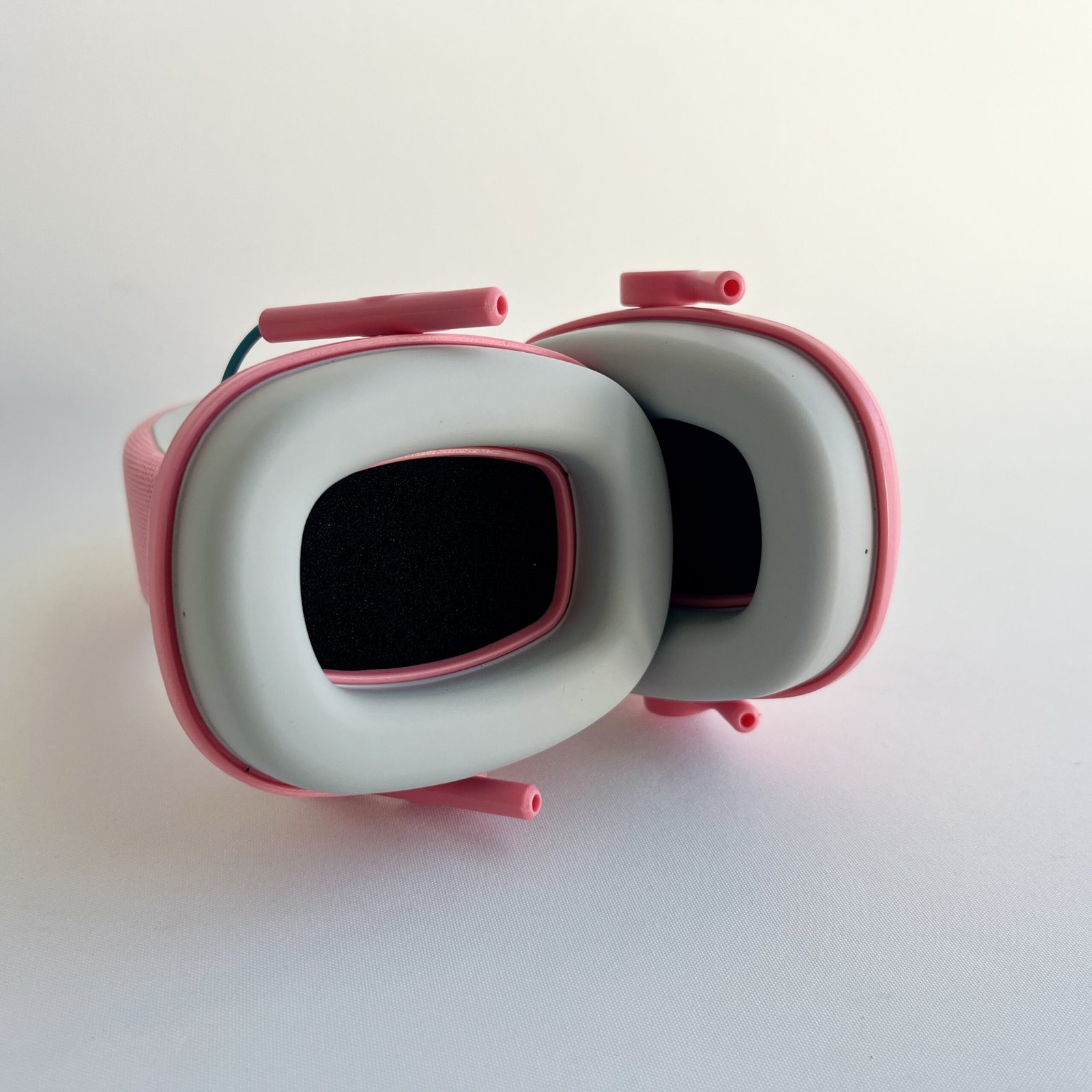 A close-up internal view of the soft, padded ear cups of a pink noise cancelling headphone, emphasizing the comfort and sensory protection they provide.