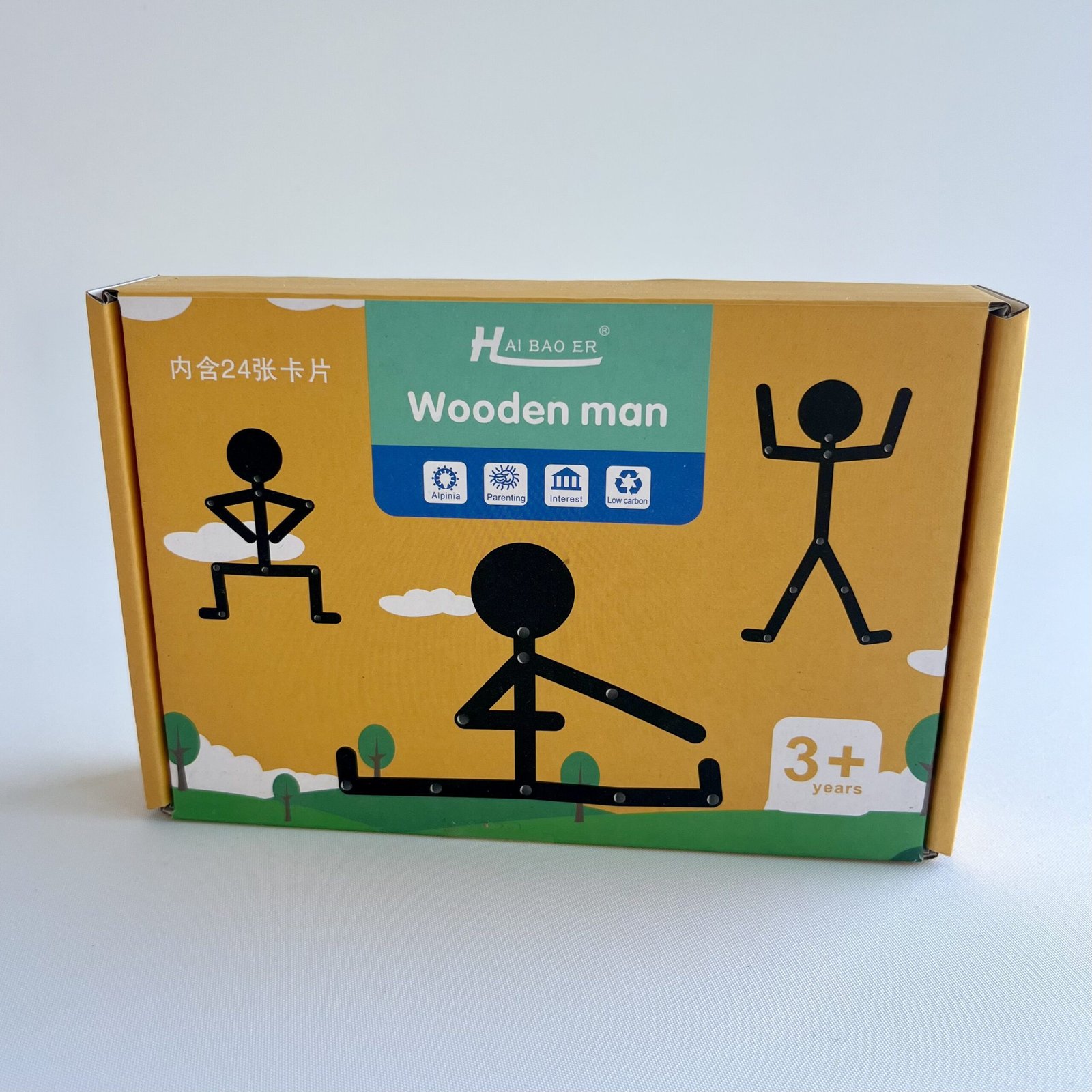 wooden-man-body-awareness-puzzle Close up of a yellow and green cardboard box for the "Hai Bao Er Wooden Man" toy, featuring stick figures in various poses and "3+ years" age recommendation.