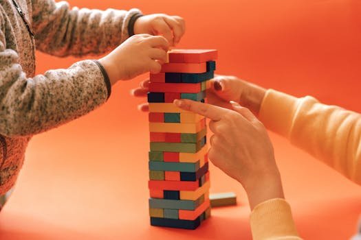 Child using occupational therapy toys to develop fine motor skills by stacking colourful blocks
