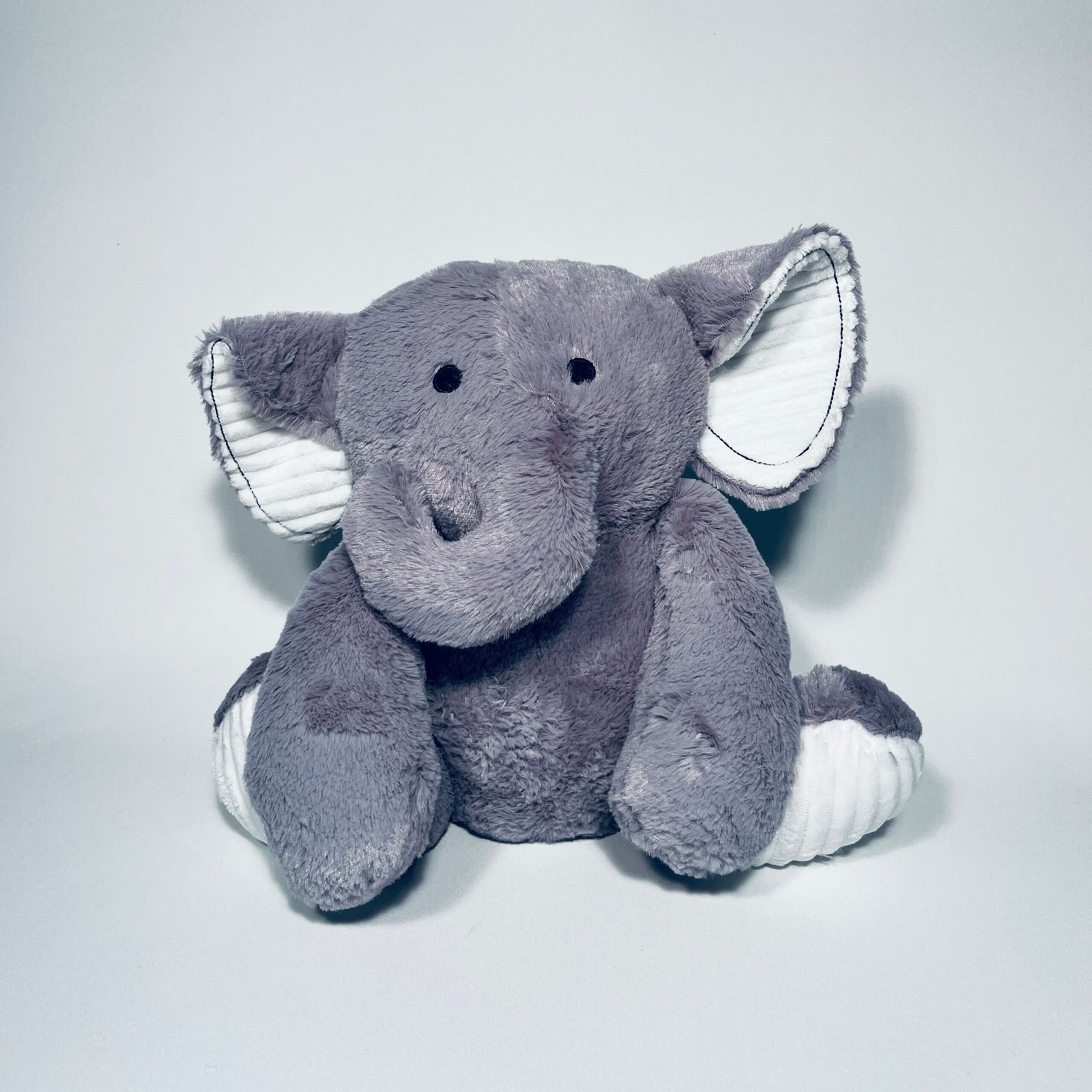 Plush grey weighted elephant teddy bear with white ribbed ears and feet, sitting on a white background, designed for deep pressure sensory input for children with autism or ADHD.
