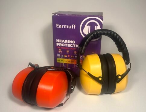 Two pairs of noise cancelling headphones for kids, one orange and one yellow, standing next to a purple Earmuff brand hearing protection box.
