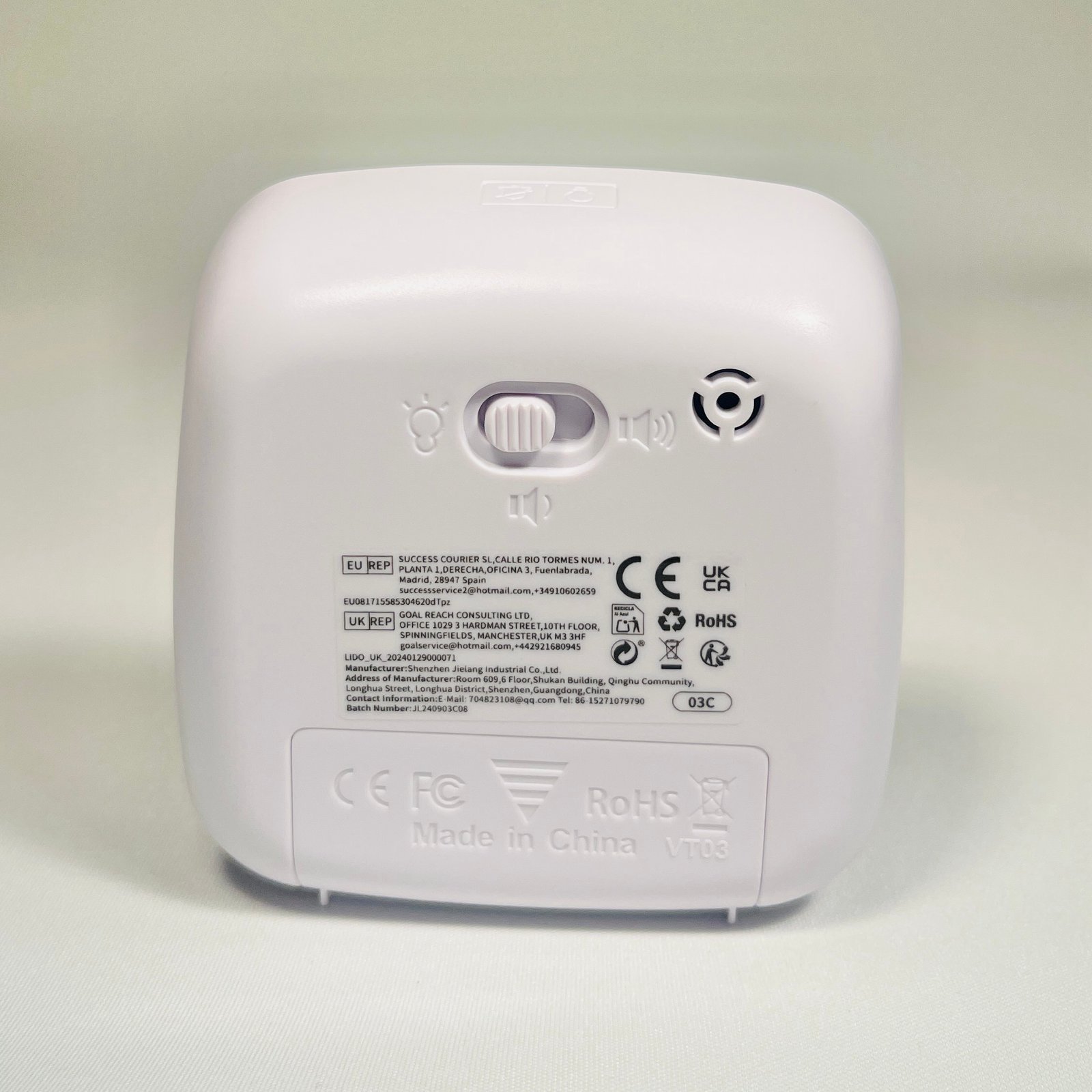 Back of the white visual timer, detailing compliance labels, manufacturer information, and a switch for light and sound settings.