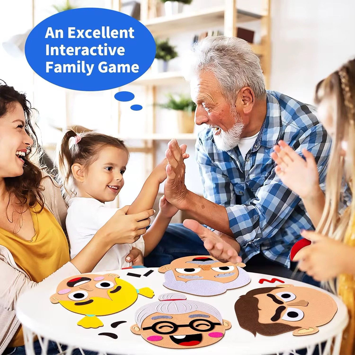 Happy family playing with Emotion Felt Faces. A young girl high-fives her grandfather while her mother smiles, with felt faces laid out on a white table, depicting an interactive family game.