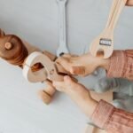 Close-up of a child playing with wooden toy tools, enhancing creativity and motor skills.
